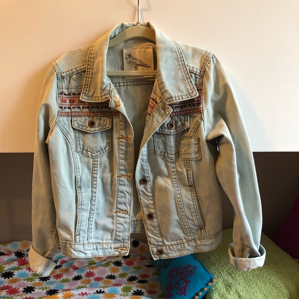 Light wash denim jacket with design stitching around shoulders